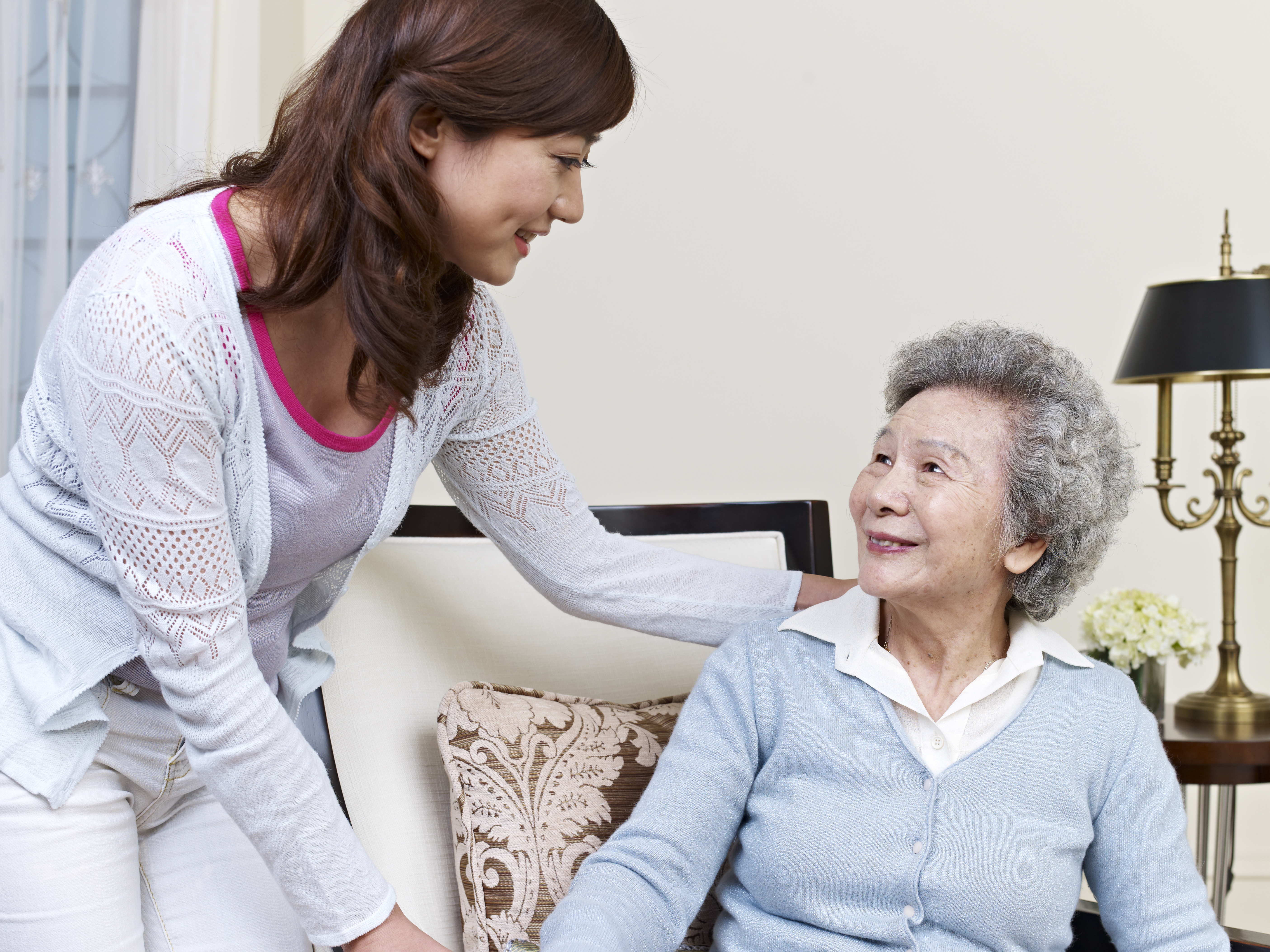 Happy Senior Woman Holding Hands With Caretaker